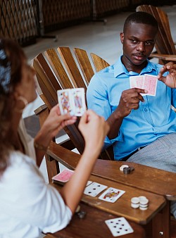 A couple playing cards : Implying that like cards, for romance we'll bluff our authenticity in exchange for careful displayed 'CARE' of the instead actor - simply character we delude upon others...